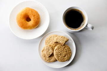 Cup of black coffee, Donut, Cookies on white marble background.  Flat lay. Top view.