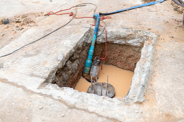 Submersible pump suck water out of pit for pour concrete foundation.