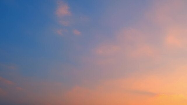 The essence of nature's beauty in a timelapse of a vibrant sunset sky. Colors cascade across the heavens, a mesmerizing spectacle of the natural world. Cloudscape background. Time lapse.
