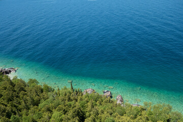 Aerial View of Clear Blue Coastline with Lush Green Forest