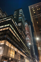 Obraz premium Illuminated Skyscrapers in a Vibrant Modern Cityscape at Night