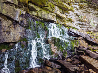 Mossy Rock Waterfall Flowing Over a Cliff in Nature..