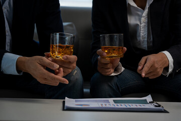 Two young men enjoying a drink during a happy hour sitting at a bar table. Lifestyle, food and drink concept.