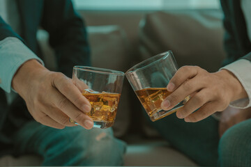 Two young men enjoying a drink during a happy hour sitting at a bar table. Lifestyle, food and drink concept.