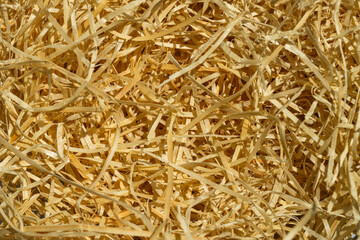 Packaging material. Straw for packing fragile items. Top view of natural color shredded wood excelsior for filling inside box when sending package