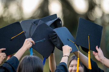 A group of people are holding up their graduation caps
