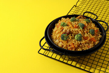 A tart with pilaf, on a yellow background.