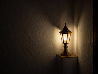 Old black vintage post lamp emits a warm yellow light glow, decoration, standing alone on a white...