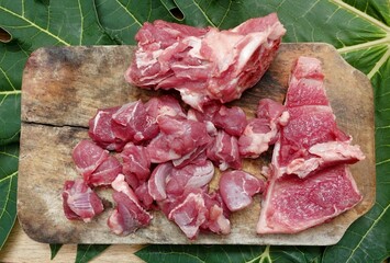Slices of fresh beef or lamb or mutton on a chopped wood and papaya leaf base. Eid al Adha...