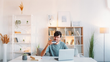 Online banking. Internet payment. Electronic transaction. Satisfied smiling man using credit card...
