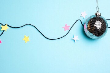 Minimalist Retro Holiday Decor with Disco Ball and Colorful Stars on Pastel Blue Background