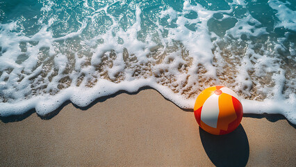 Obraz premium A beach ball on a sandy beach with waves.