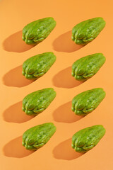 Green chayote arranged diagonally on orange background. Perfect for food blogs, recipe websites, and healthy lifestyle content creators.