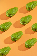 Green chayote arranged diagonally on orange background. Perfect for food blogs, recipe websites, and healthy lifestyle content creators.