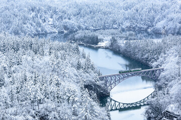 積雪の只見川第1橋梁を渡る只見線の気動車