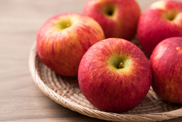 Red apple fruit (Envy apple) in basket on wooden background
