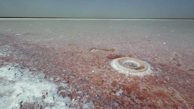 Endless salt flat landscape of Sebkha el Melah in Zarzis, Tunisia, extending to horizon with glistening salt crusts remained from evaporated water body under intense sun, creating mosaic-like pattern