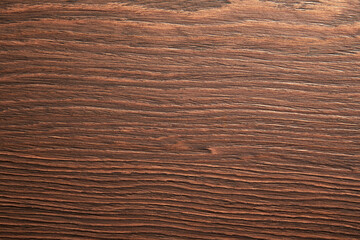 Close-up shot of a dark brown wood texture with a natural grain pattern. The wood has a rustic feel