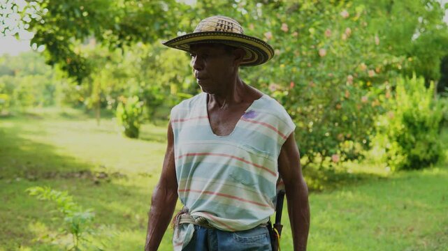 Campesino o trabajador del campo de la costa colombiana, cultivador de mata de yuca, tuberculo o raiz.  vestimenta de finca o campo con sombrero vueltiao, con machete, botas pantaneras y perro fiel.