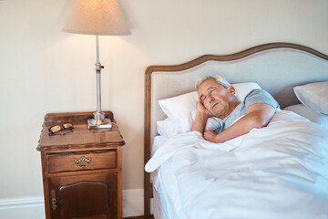 Senior man, sleeping and bed with lamp light for morning, rest or recovery in retirement home....