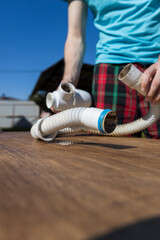 A man is holding a white pipe and a blue pipe