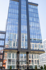 Naklejka premium A tall building with a lot of windows and a reflection of it in the glass