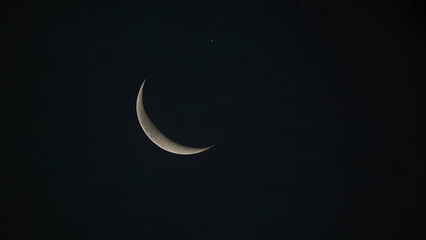 Close-up of a waxing crescent moon glowing against a dark night sky.