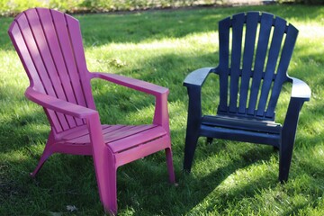 pink and navy adirondack chairs in the grass lawn. summer or vacation lifestyles design element or banner