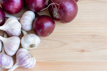 garlic and red onion lying on a wooden background, autumn harvest, copy space. High quality photo