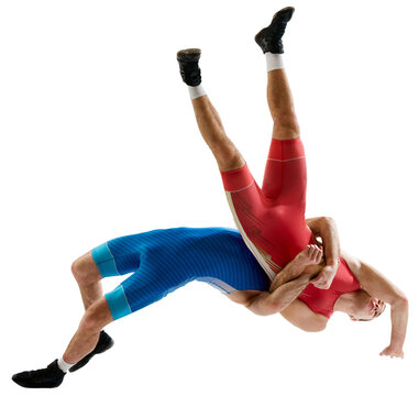 Dynamic shot of two professional Greco-Roman wrestlers in red and blue uniform wrestling against transparent background. Concept of motion, action, combat sports, strength and power, movement,