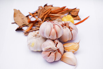 Whole onions accompanied by an assortment of spices on a white background. Cooking ingredients concept