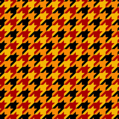 Houndstooth seamless pattern. Classical autumn black, red, orange and yellow fabric background. Tweed pepita plaid texture. Traditional fall and winter fashion print design. Abstract simple background