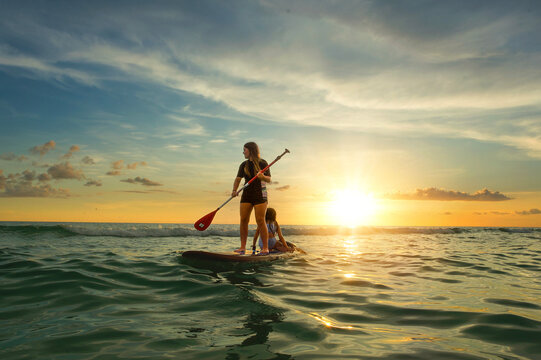 Sisters paddle boarding at sunset Anna Maria Island