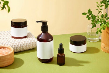 Beauty products advertising template showcases four amber glass beauty products, pink salt bowl, white towel, and green leaves, surrounded by a yellow wall background