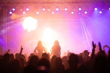 Crowd at concert and colorful stage lights.