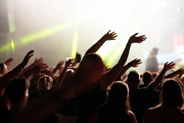 Crowd at concert and colorful stage lights.