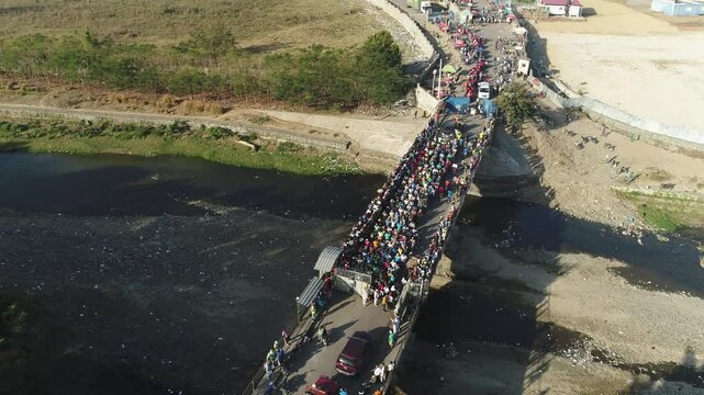 Aerial shot of Haitians crossing a bridge into the Dominican Republic, highlighting migration and border interaction. A glimpse into the realities of the border between both countries.