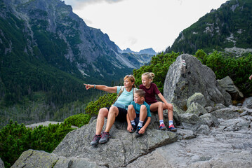 Grandmother with grandchildren on hike in autumn mountains. Kids spending summer break in nature...
