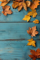 Obraz premium Autumn leaves on a wooden teal background