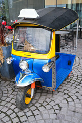 Blue three wheel car in the city