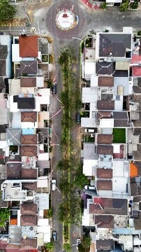 Vertical top shot of residential street lined with colorful roofed houses in Tuban Regency, East Java, Indonesia