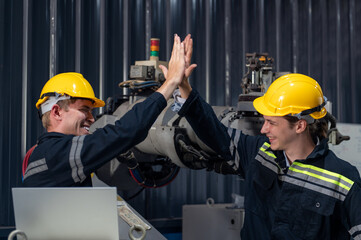 Fototapeta premium Engineer standing by robotic arm and operating machine in industry factory, technician worker check for repair maintenance electronic operation