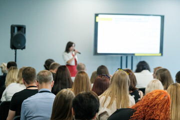 Obraz premium Business professional giving speech at a conference with audience members listening attentively in a seminar room.