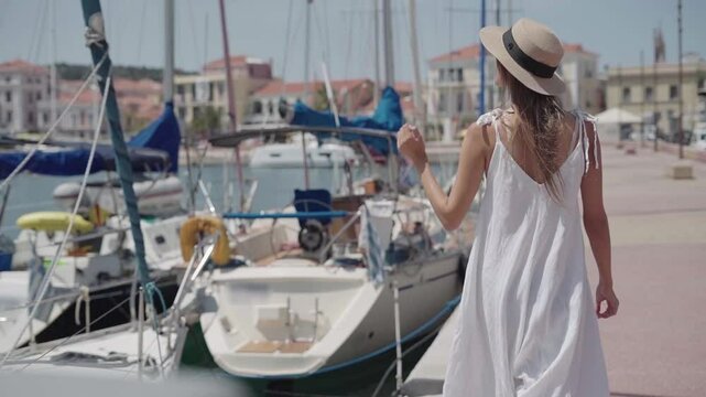 solo female traveler walking by yachts in the harbor near Molyvos, island of Lesvos, Greece