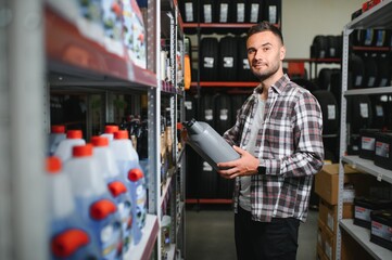 seller man with canister of motor oil in auto store