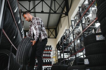 customer tire fitting in the car service, auto mechanic checks the tire and rubber tread for safety