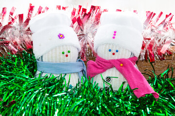 Couple of snowman from white sock in hat and pink scarf