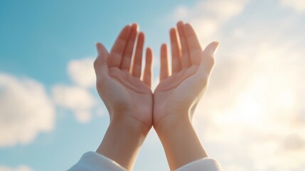 Open hands raised towards a bright sky with soft clouds during daylight, symbolizing hope and openness to the world.