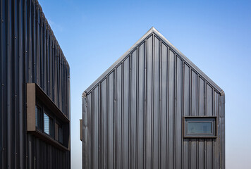 Fototapeta premium Architecture details of modern black metal sheet facade storage house with gable roof minimal style