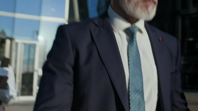 Handheld shot of confident Caucasian mature businessman or politician in blue suit and tie refusing to give any comments to press after press conference